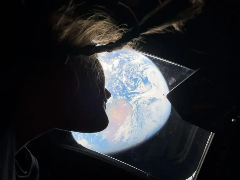 specialist Christina Koch looks at Earth from the window of the Orion spacecraft on its way to the Moon during the Artemis II mission. photo by NASA